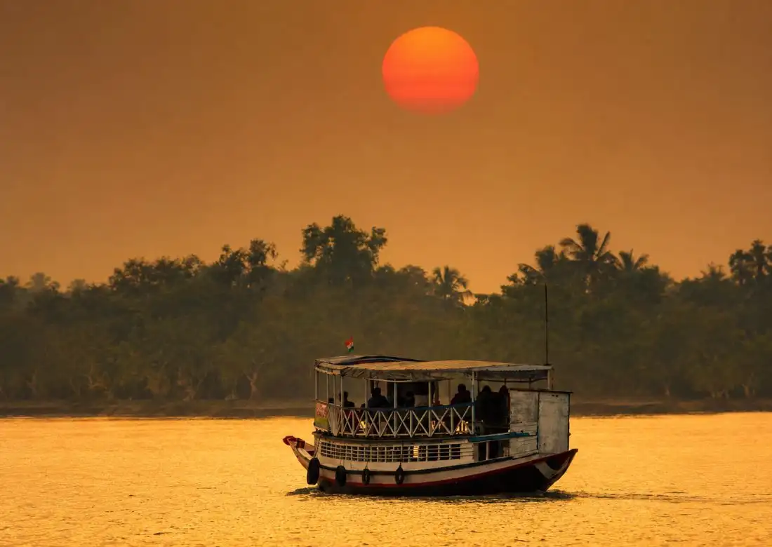 Sundarban tour operator boat cruise sailing on river during beautiful sunset in mangrove forest